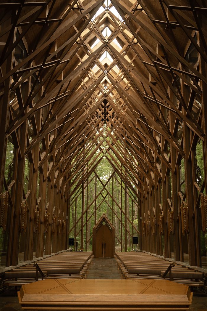 Interior of a timber chapel, light coming through the lattice of the roof