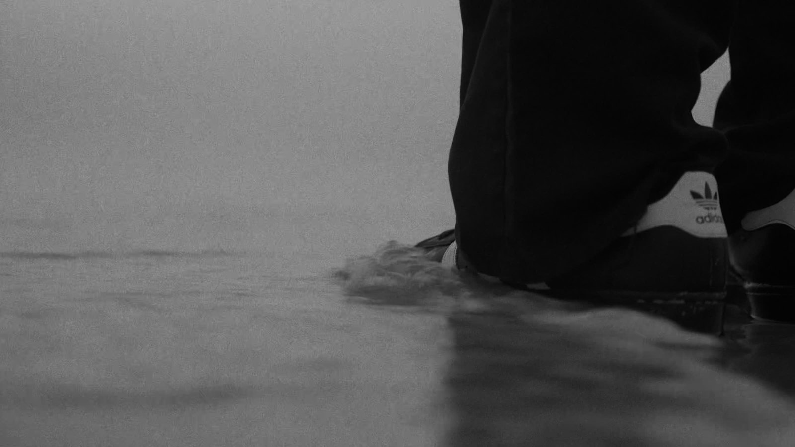 Shoes at the water’s edge in monochrome